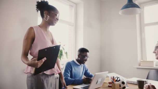 Boldog afro-amerikai női vezérigazgatója motiválja a kollégák. Többnemzetiségű üzletemberek együttműködnek a modern office 4k. — Stock videók