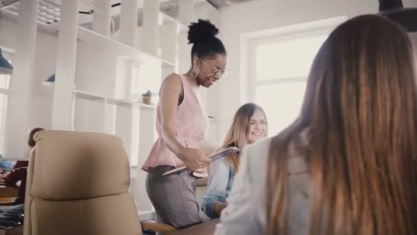 Heureuse femme d'affaires afro-américaine parle à des amis dans un bureau moderne. Multiethnique jeunes collègues brainstorming 4K . — Video