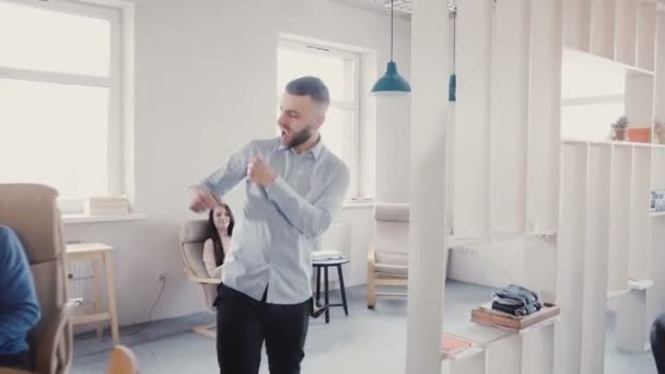 Succesvolle jonge zakenman vieren voltooiing met gekke dans lopen. Gelukkig knappe mannelijke Ceo in moderne kantoor 4k. — Stockvideo
