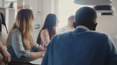 Modern ışık trendy çok ırklı ofis toplantı, takım çalışması. Mutlu Avrupa Yöneticisi küçük küre alır, ülke 4 k gösterir.