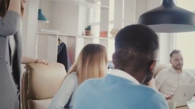 Çok ırklı meslektaşları ile office toplantısında konuşan kendine güvenen kadın patron. Güzel iş kadını takım 4 k motive eder..