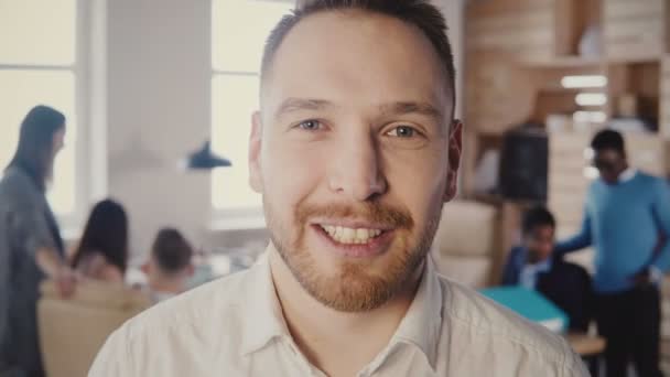Close-up πορτρέτο της ευτυχισμένη Ευρωπαϊκό επιχειρηματίας που εργάζεται στη σύγχρονη φως γραφείο, βλέπουν κάμερας Θέτοντας και χαμογελαστός 4k. — Αρχείο Βίντεο