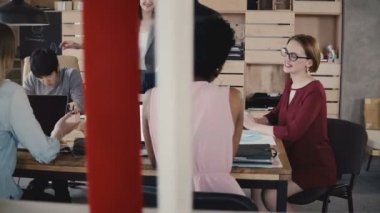 Kadın takım lideri kadar gelir, çok ırklı iş takım toplantısı modern ofis 4 k arkadaşları için talimat verir.