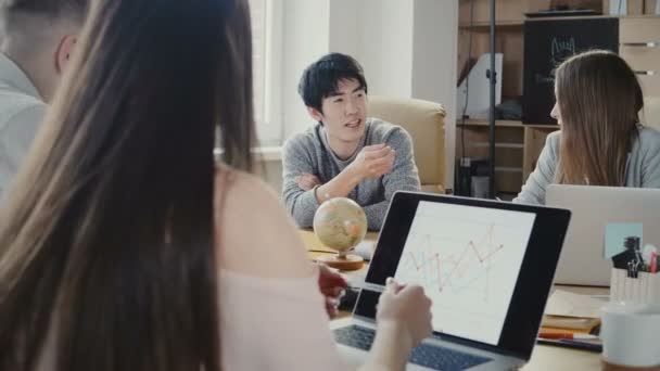 金融会社のスタッフ ・ ミーティングで言えば幸せなアジア青年実業家。多民族チーム話し合う cryptocurrencies 4 k. — ストック動画