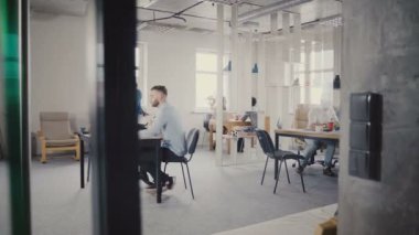 Dolly atış mutlu ofis arkadaşları sağlıklı ofis çalışmaktan zevk etnisite karışık. 4 k cam duvardan görüntülemek.
