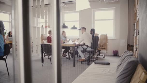 Dolly toma de trabajo en equipo en un lugar de trabajo moderno y saludable. Líder femenina feliz ayudando a colegas multiétnicos con el proyecto 4K . — Vídeo de stock