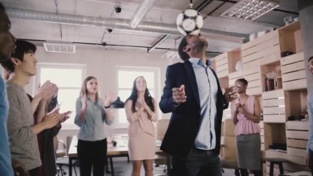 Heureux patron afro-américain jongle balle sur la tête. Les gens d'affaires multiethniques célèbrent le succès au ralenti au bureau — Video