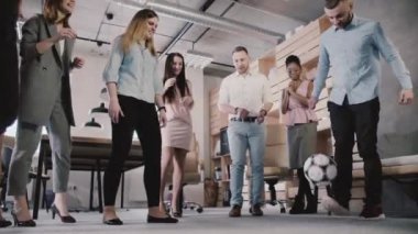 Modern ofis top ile genç casual arkadaşları oyun. Mutlu çok ırklı çalışanlar fiziksel aktivite yavaş tadını çıkarın.