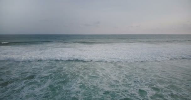 Беспилотник летит к большой белой пенной океанской волне, достигая берега и разбиваясь, создавая удивительную природную текстуру воды . — стоковое видео