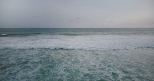 Drone volando hacia una gran ola blanca y espumosa que llega a la orilla y se estrella, creando una increíble textura natural del agua . — Vídeos de Stock