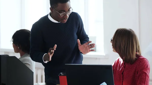 Joven empresario africano profesional discutiendo trabajo con jefa mujer de mediana edad en un lugar de trabajo de oficina saludable . —  Fotos de Stock