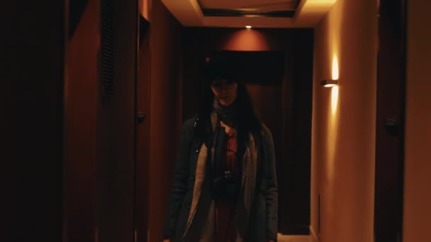 Mooie jonge elegante Europese vrouw loopt in de richting van camera glimlachend langs hotel hal poseren slow motion — Stockvideo