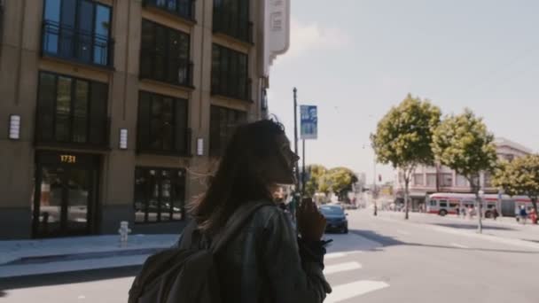 Increíble toma en cámara lenta de feliz mujer turística relajada con mochila disfrutando del soleado paseo callejero de San Francisco . — Vídeo de stock