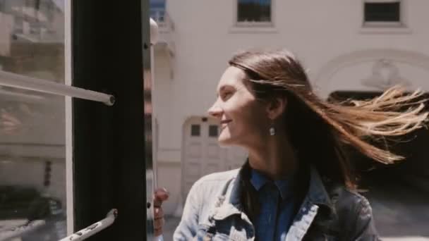 Primer plano feliz sonriente joven turista montando famoso teleférico de San Francisco con el viento en su pelo en las vacaciones de EE.UU. . — Vídeo de stock