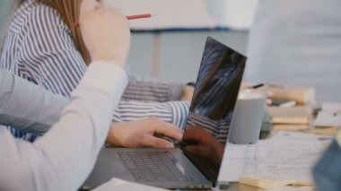Ofis masasının arkasındaki erkek yazılım geliştiricisinin ellerinin dizüstü bilgisayarı ile şirket toplantısına katılışını yakından çek..