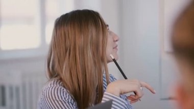 Genç mutlu gülümseyen beyaz kadın ofis müdürü personel eğitim seminerinde uzman konuşmacının konuşmasını dinliyor..