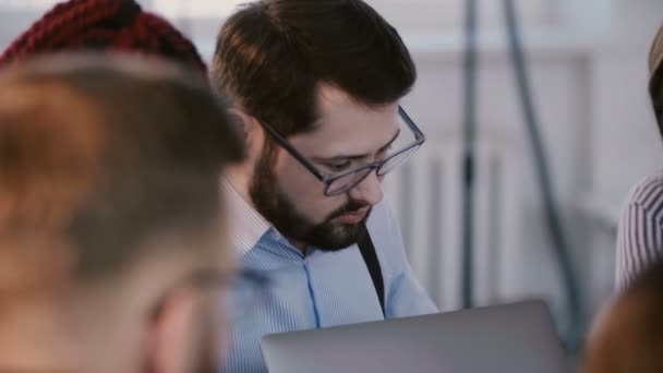 Młody, przystojny, biały deweloper biznesmen współpracujący z kolegami na spotkaniu pracowników firmy. — Wideo stockowe