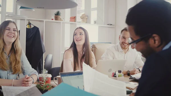 La entrenadora de negocios europea motiva al equipo por la mesa. Hermosa mujer jefe conduce mixta carrera oficina reunión 4K . — Foto de Stock