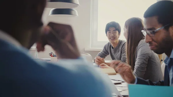 Feliz gerente asiático hablando en la reunión de oficina multiétnica. exitoso hombre de negocios sonriendo a la luz moderna coworking 4K — Foto de Stock