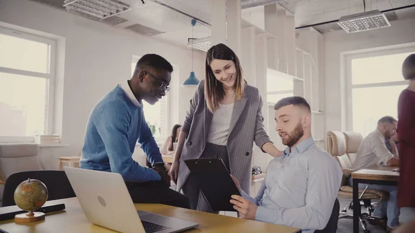 Jefe femenino caucásico ayudando a jóvenes colegas multiétnicos. Mujer gerente motiva a los empleados en la oficina moderna loft 4K . — Foto de Stock