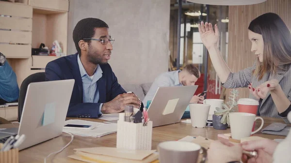 Hombres afroamericanos serios escuchan a una mujer de negocios europea líder en una moderna reunión multiétnica de oficina 4K . — Foto de Stock