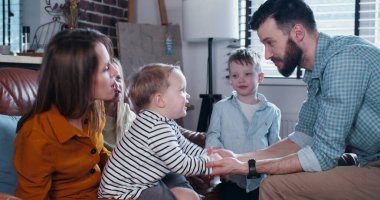 Aile bağları, genç Avrupalı ebeveynler küçük çocukların el ele tutuşması ve yavaş çekimde eğlenmeleri..