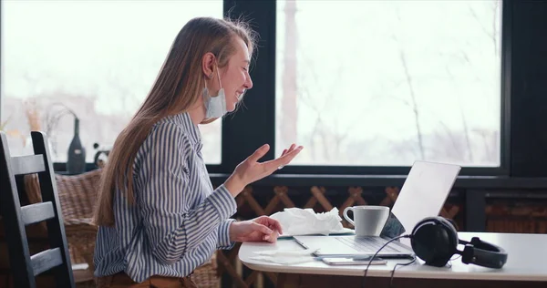 Side view jonge gezonde gelukkige vrouw het maken van video bellen op laptop om te chatten met vrienden van thuis met gezichtsmasker op de hals. — Stockfoto