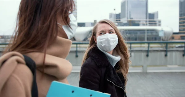 Controllo epidemico degli assistenti sociali. Due giovani medici caucasici in maschera camminano sulla strada della città durante la quarantena . — Foto Stock