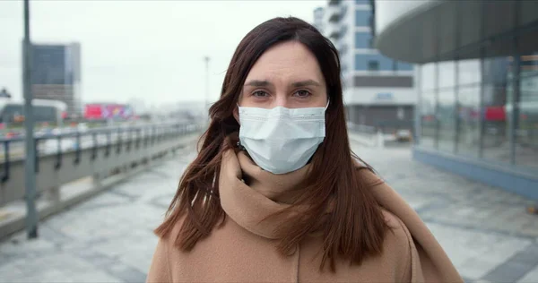 Protecção epidémica. Retrato da bela mulher caucasiana em máscara médica na rua da cidade vazia durante a quarentena . — Fotografia de Stock