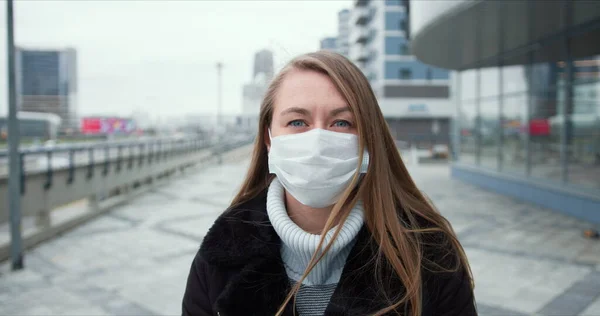 Protecção epidémica. Retrato de jovem europeia usando máscara no rosto ao ar livre, a rua está vazia durante a quarentena . — Fotografia de Stock