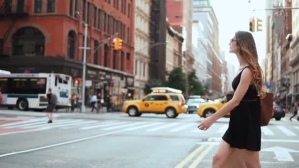 Mulher bonita jovem atravessando a estrada em Nova York, América, segurando os sacos de compras. Movimento lento . — Vídeo de Stock