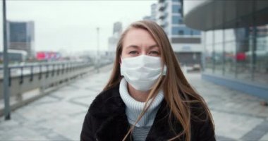 Salgın hastalık koruması. Açık havada maske takan genç Avrupalı kadın portresi, karantina sırasında sokak bomboş..