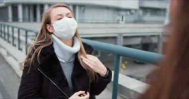 Salgın krizi sırasında korku ve panik atmosferi. Rüzgarlı bir günde dışarıda tıbbi maske takan beyaz bir kadın..