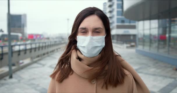 Protección epidémica. Retrato de la hermosa mujer caucásica en máscara facial médica en la calle vacía de la ciudad durante la cuarentena . — Vídeo de stock