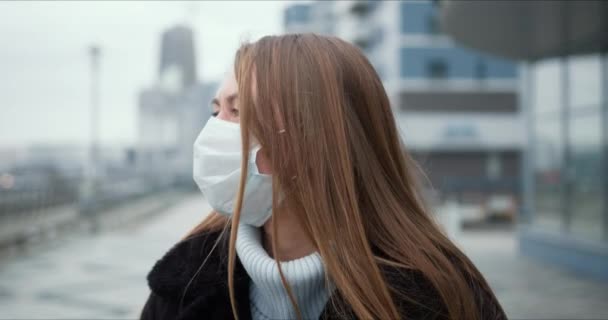 Epidemic quarantine. Portrait of young Caucasian woman wearing mask outdoors, turning head to camera in empty street. — Stock Video