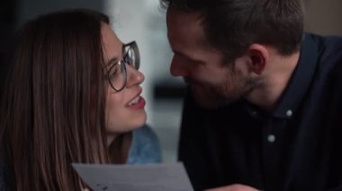 Yakın çekim romantik Kafkasyalı çift, Noel hediyesi kutusunu yavaş çekimde gönderdikten sonra kartpostal okuyor..