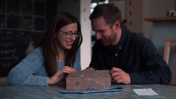Aufgeregt junge kaukasische junge romantische Paar öffnet Urlaub Geschenk Lieferbox mit magischem Licht in Zeitlupe. — Stockvideo