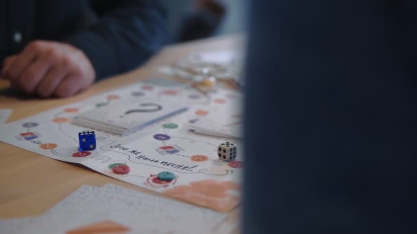 Home recreatieve spelletjes en saamhorigheid concept, vrienden spelen leuke creatieve bordspel met dobbelstenen en kaarten slow motion. — Stockvideo