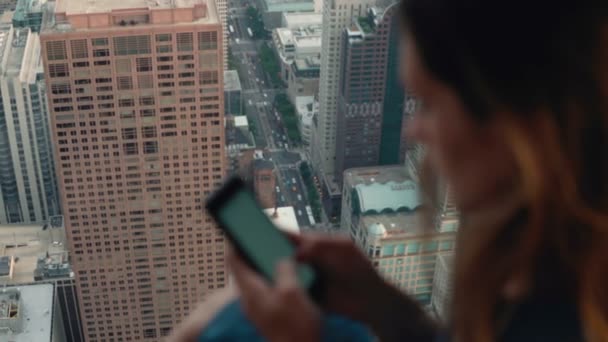 Junge attraktive Frau mit Smartphone. Frau steht in Wolkenkratzer in Chicago am Fenster. — Stockvideo