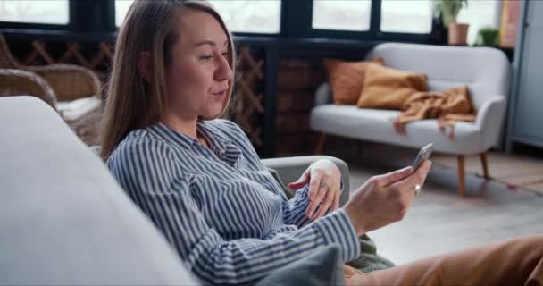 Jovem mulher médica loira feliz consultando pessoas no aplicativo de chamada de videoconferência smartphone a partir de casa no auto-isolamento . — Vídeo de Stock