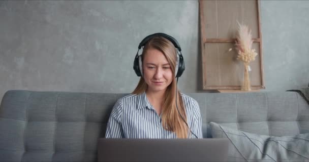Porträtt av glad hälsosam frilansande arbetstagare kvinna med hjälp av laptop och hörlurar för att arbeta hemifrån på självisolering period. — Stockvideo