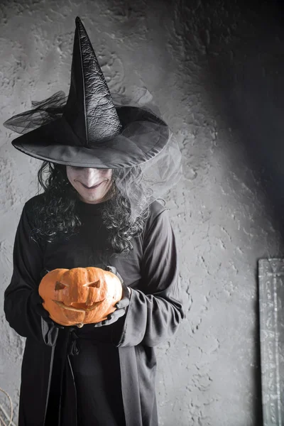 Bruja de Halloween sosteniendo una calabaza — Foto de Stock