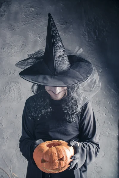 Halloween-Hexe mit einem Kürbis — Stockfoto