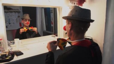 Palyaço MIME makyaj performans soyunma odasında oturuyor sonra yüzünü yıkar