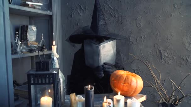 Halloween czarownica siedzi przy stole i machając ręką — Wideo stockowe