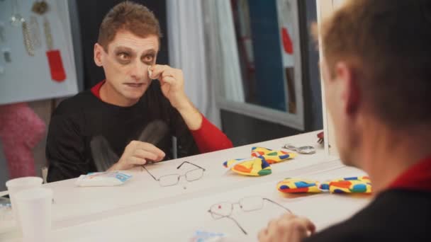 Clown mime makeup tvättar bort ansiktet efter föreställningen, sitter i omklädningsrummet — Stockvideo