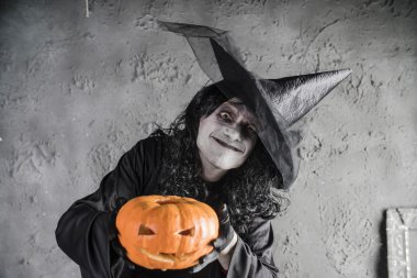 Balkabağına tutan Halloween cadı