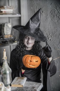 Balkabağına tutan Halloween cadı