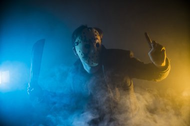 bir beyaz adam seri katil maskesi Portre siluet Studio ile korkunç hokey beyaz maske genç adam threateningly pala brandishing