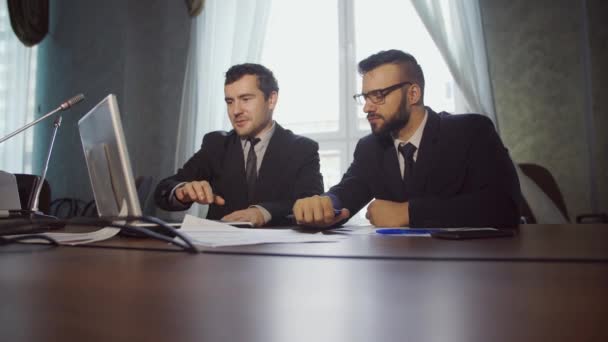 Jeune homme d'affaires assis au bureau et travaillant avec un ordinateur portable — Video